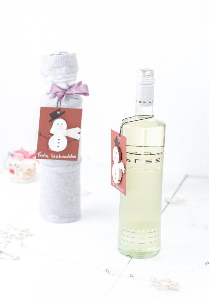 Weinflaschen weihnachtlich verpacken mit Socken und einem DIY Schneemann Geschenkanhänger - inspiriert von Bree Wein
